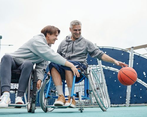 Couple of friends in wheelchairs playing together